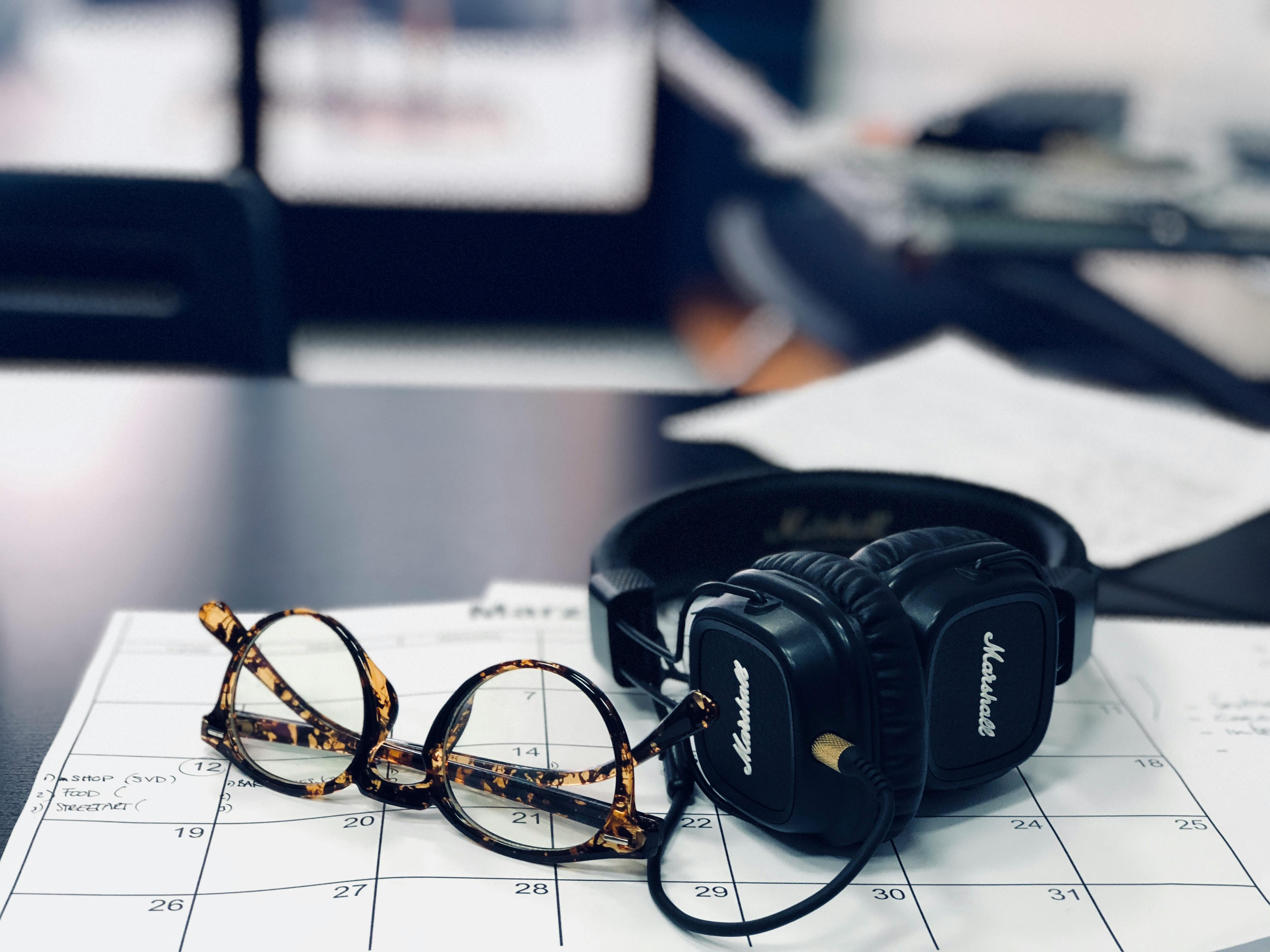 Photo of a calendar, glasses, and headphones